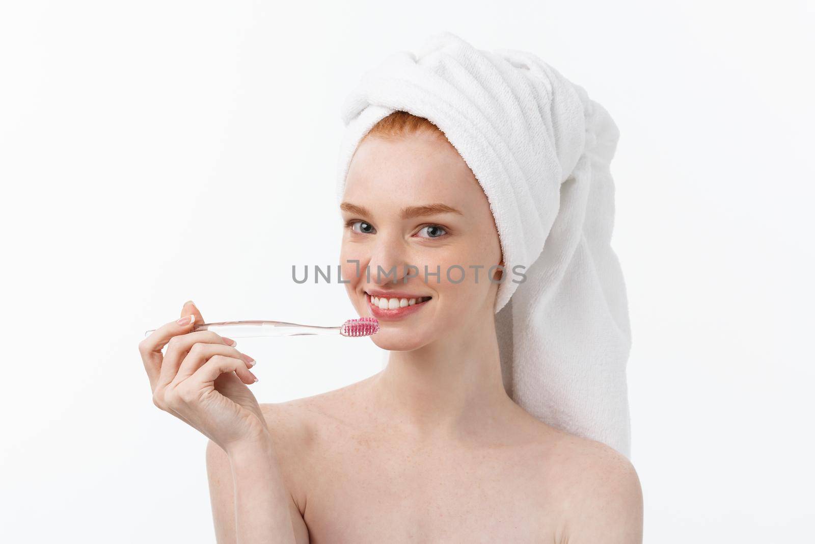 Portrait of young woman with toothbrush on grey background