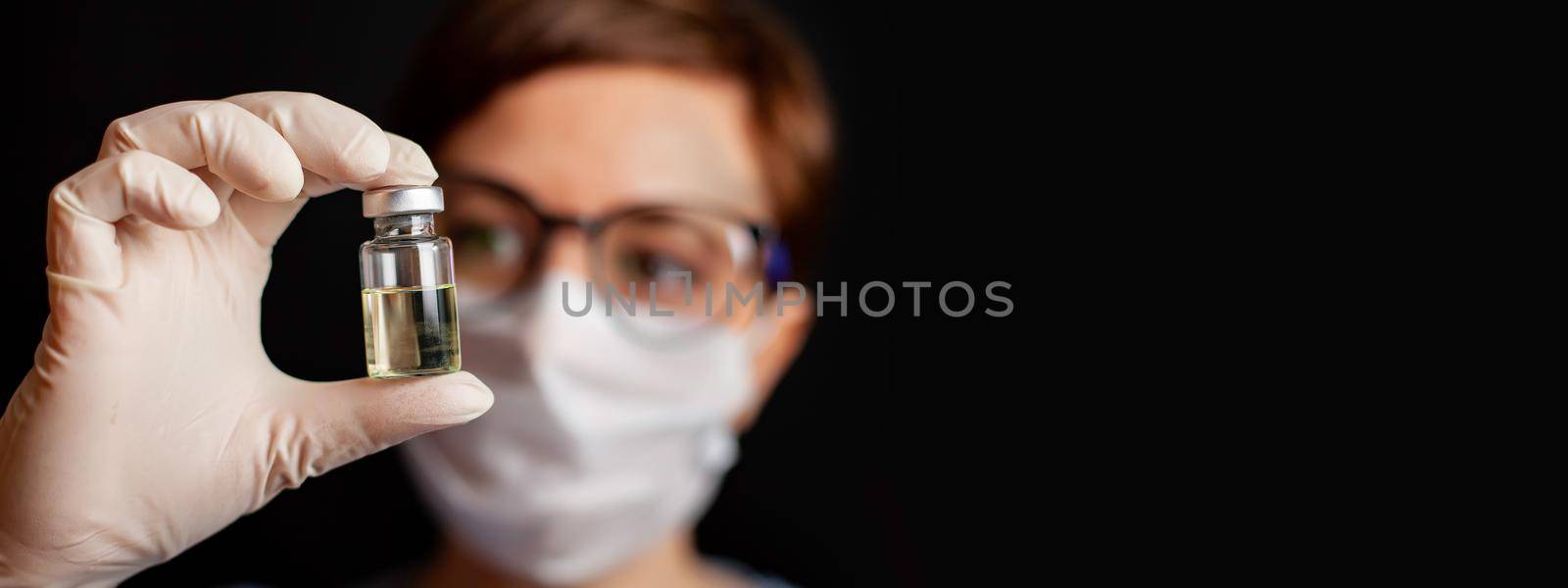 A doctor or nurse in nitrile gloves holds in his hand a vaccine vaccinated against influenza, measles, coronavirus COVID-19 for vaccination of children and adults, the concept of medicine and drugs.