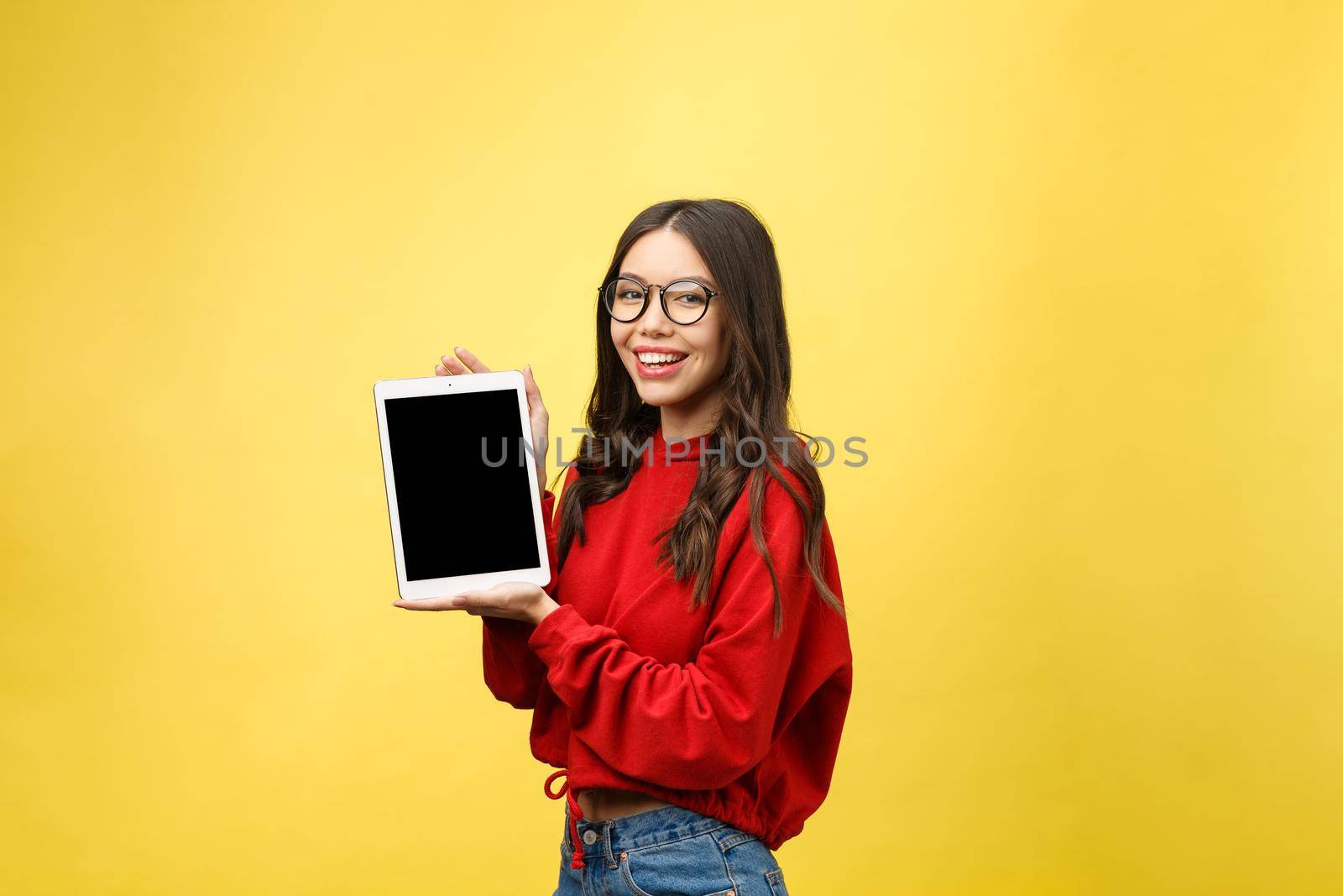 Woman using digital tablet computer PC isolated on yellow background.