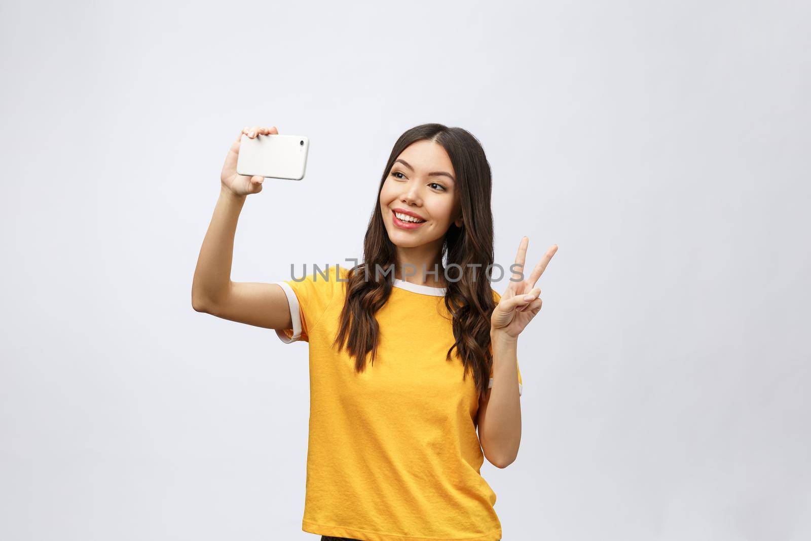 Image of excited happy young woman isolated over grey background make selfie by camera