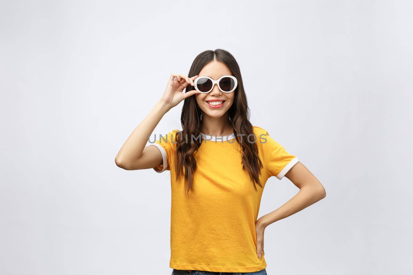 A portrait of a beautiful and cute young lady posing over white background. Fashion concept