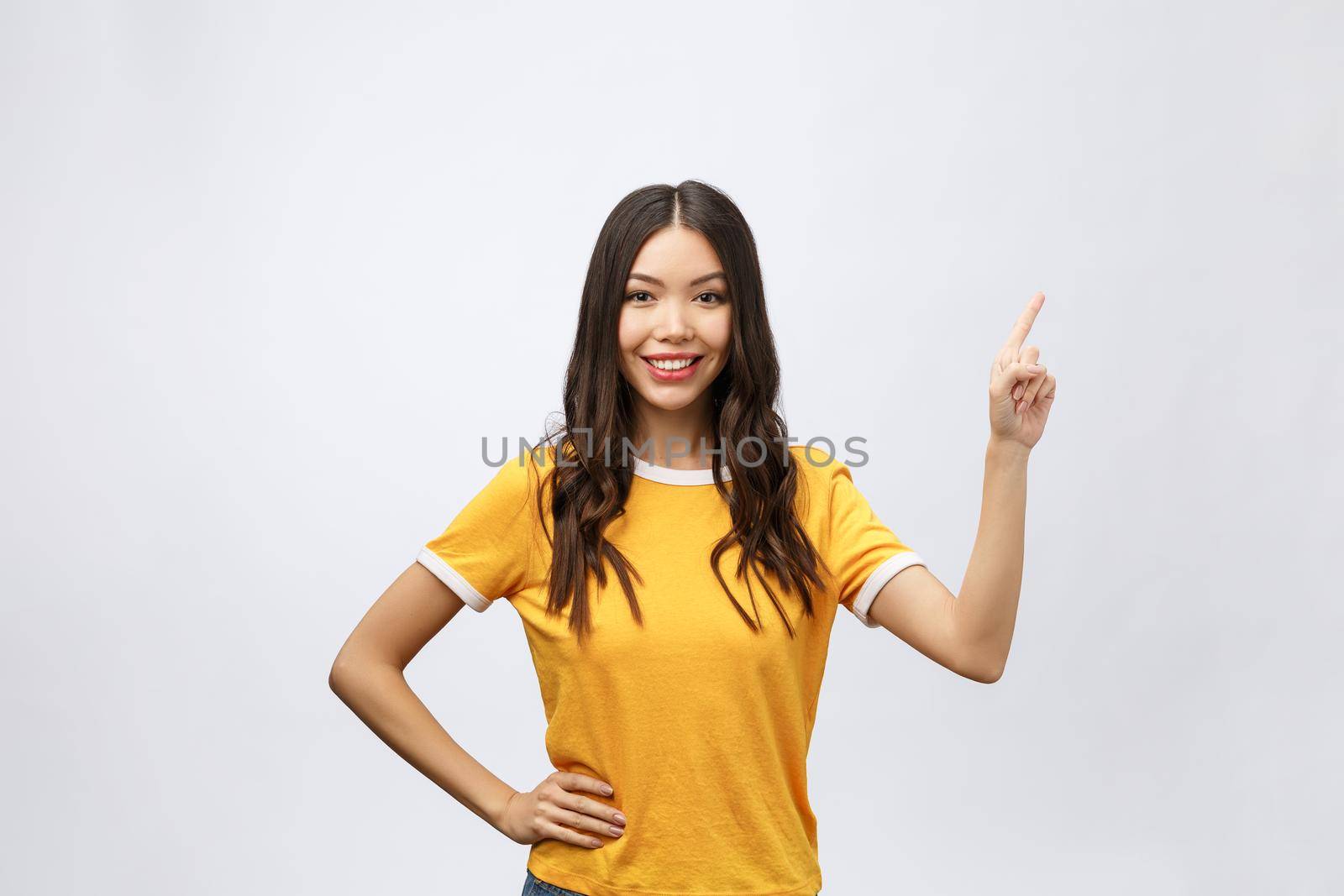 Portrait of happy young asian woman with finger point up.