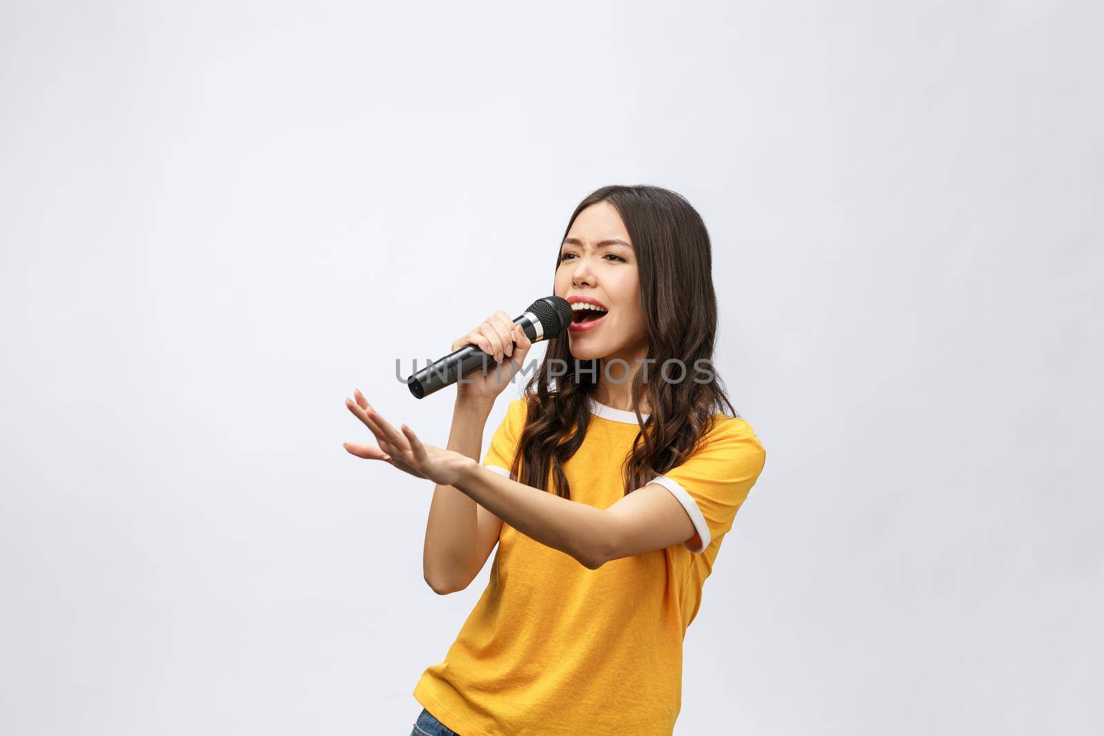 beautiful stylish woman singing karaoke isolated over white background