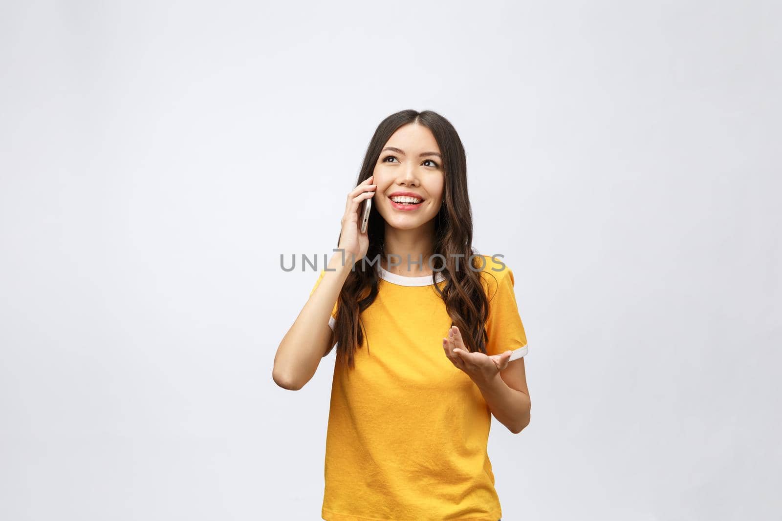 Beautiful young asian woman talking mobile phone and smile standing on grey background, freelancer female calling telephone, communication concept.