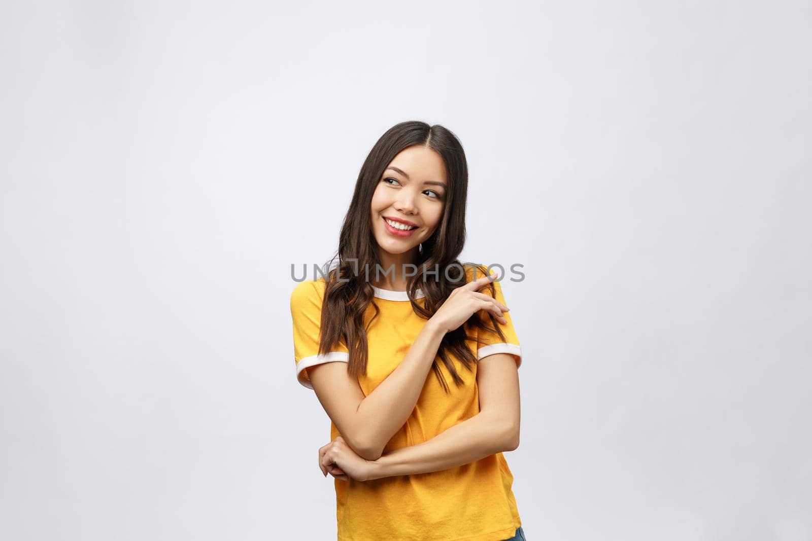 Beautiful young woman portrait. Smiling asian lifestyle concept with crossed arms. Isolated on grey background.