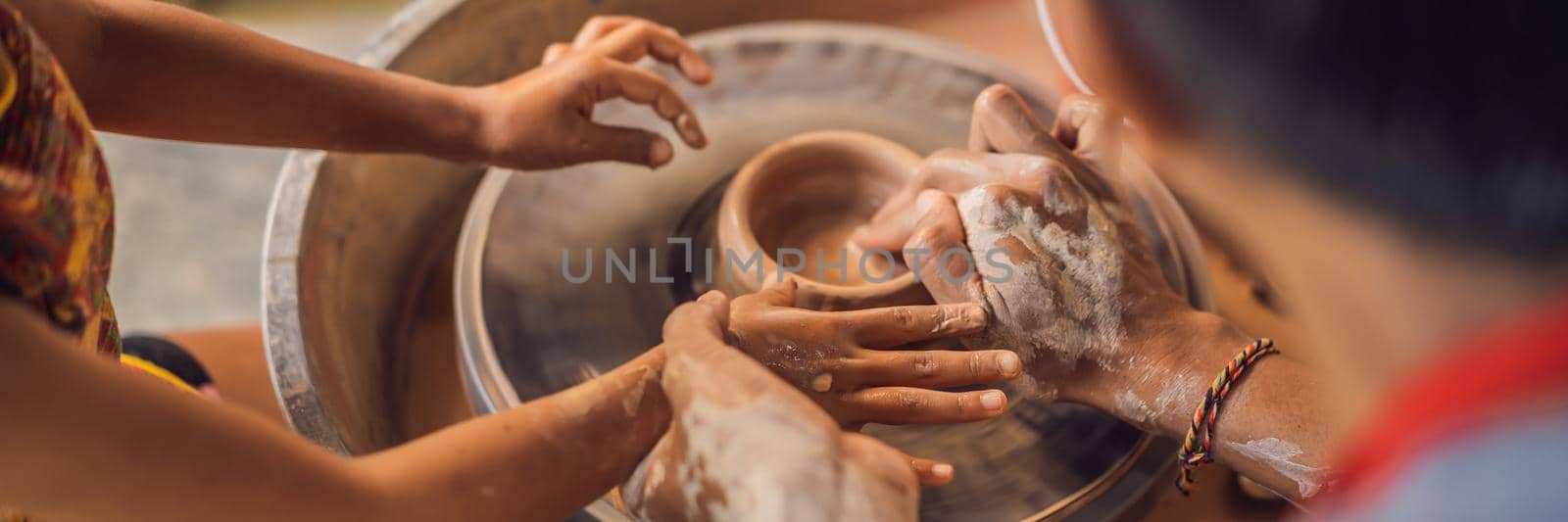 Father and son doing ceramic pot in pottery workshop. BANNER, LONG FORMAT