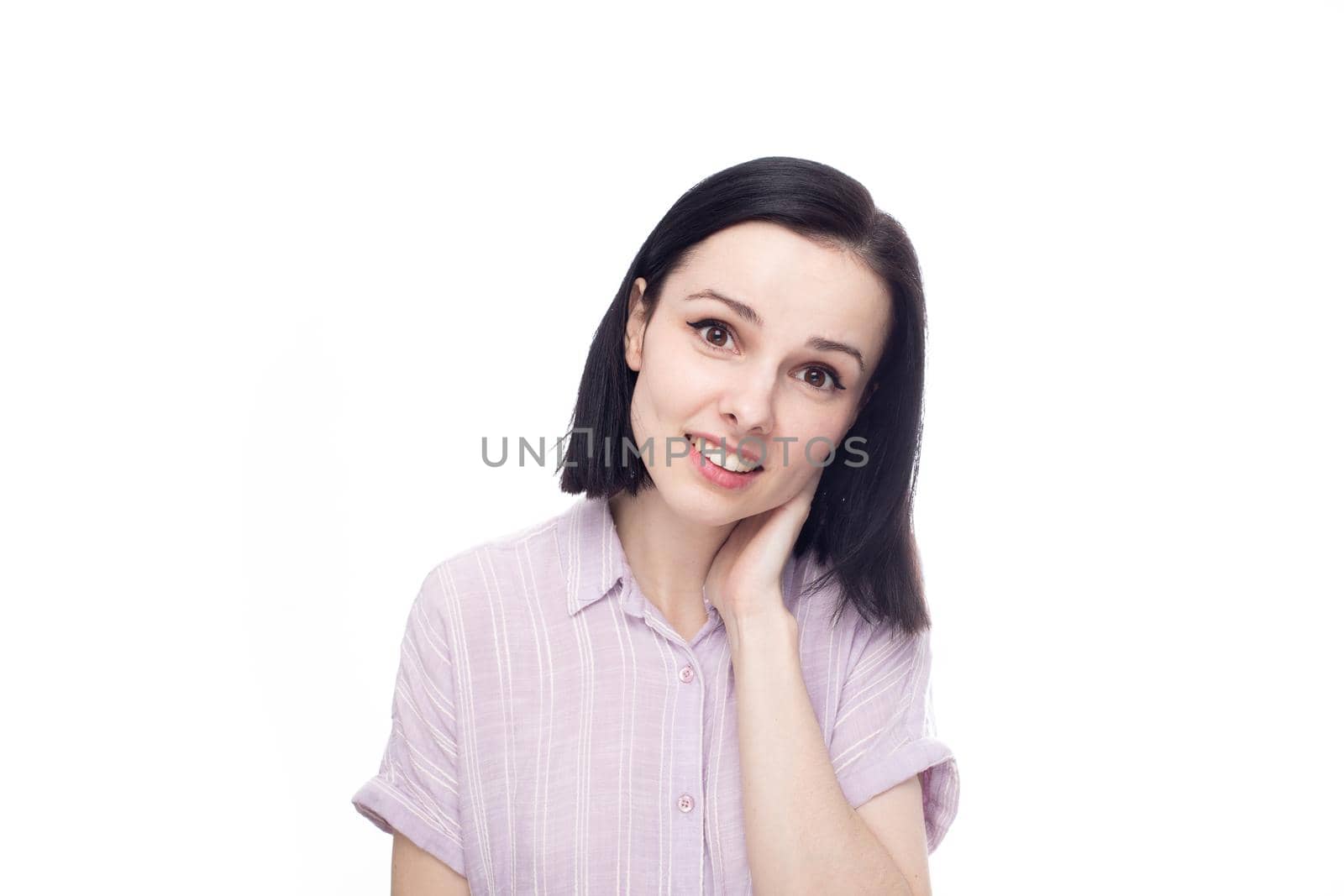 smiling woman in lavender shirt touching herself with one hand, white background. High quality photo