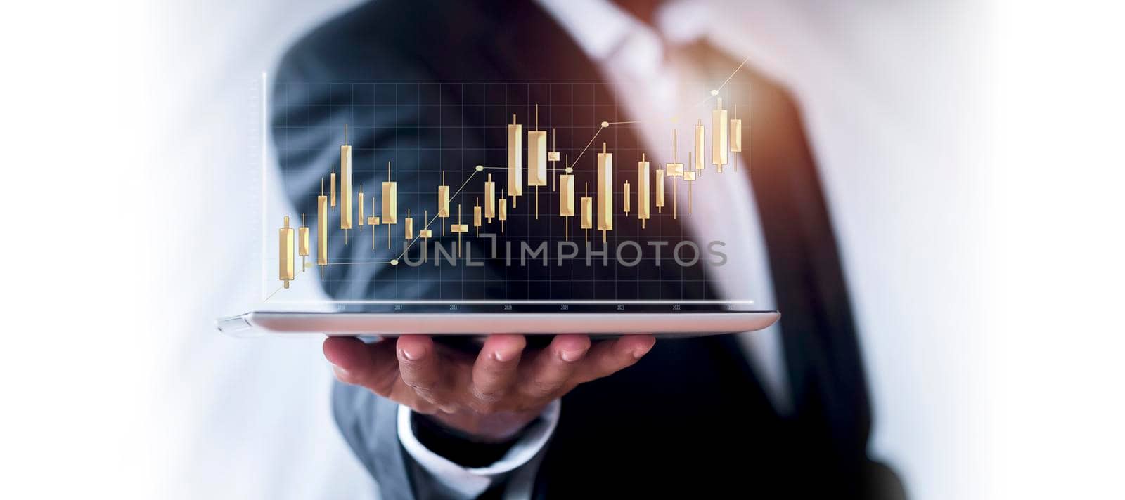 Hand of businessman holding tablet analysis stock market graph growth and increase of chart positive indicators. Hand holding tablet show stock chart on light gray background. copy space banner