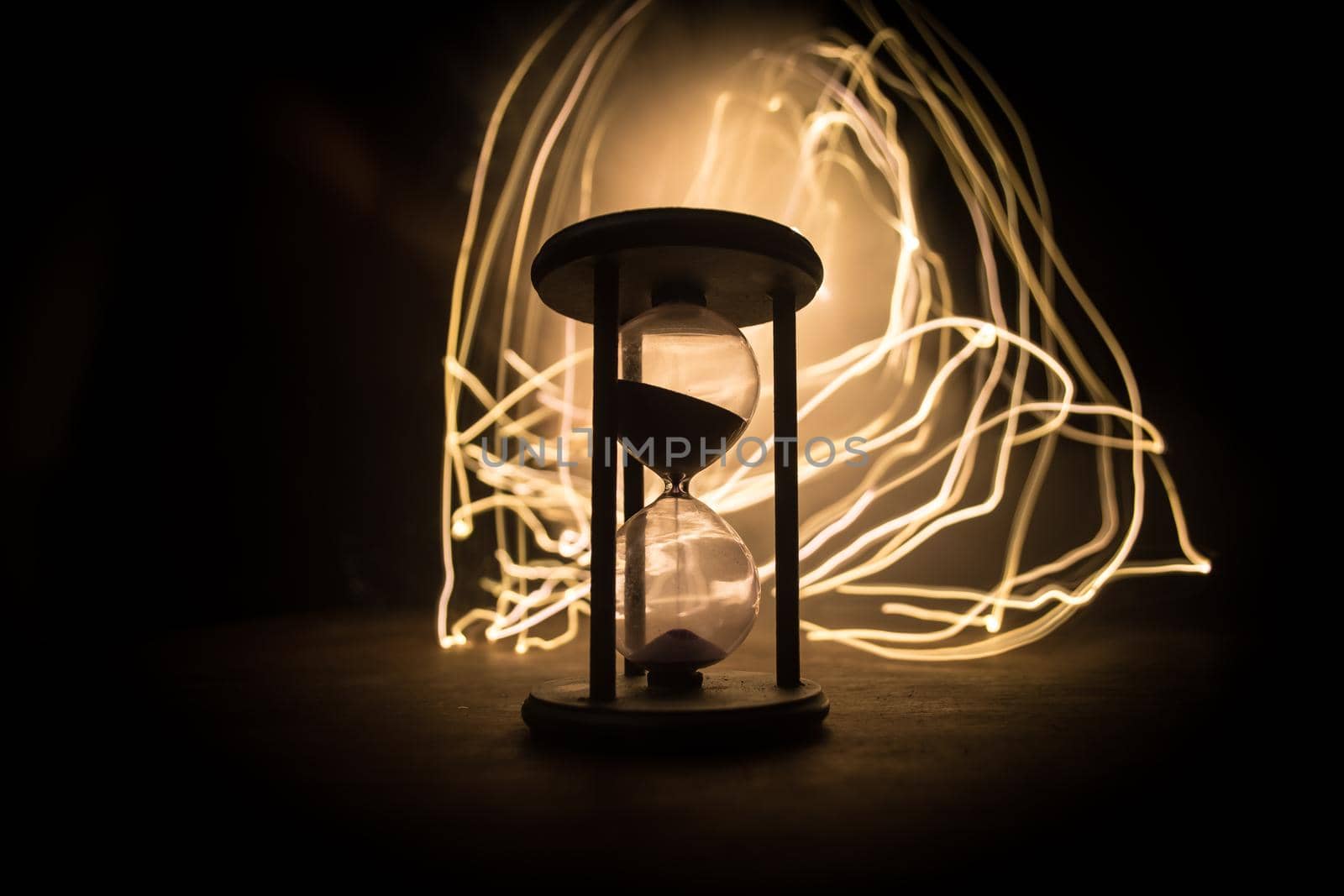 Time concept. Silhouette of Hourglass clock on dark toned background. Abstract concept with copy space. Selective focus