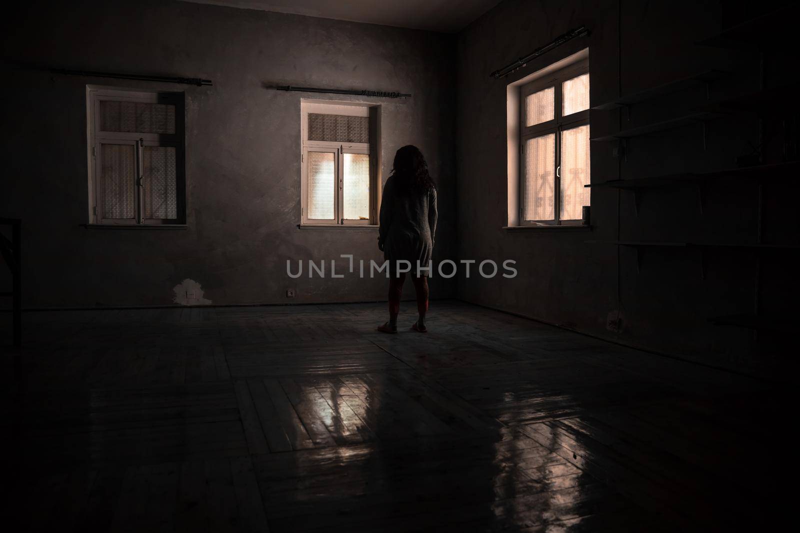 Horror silhouette inside abandoned creepy room with window at night. Horror scene. Halloween concept.