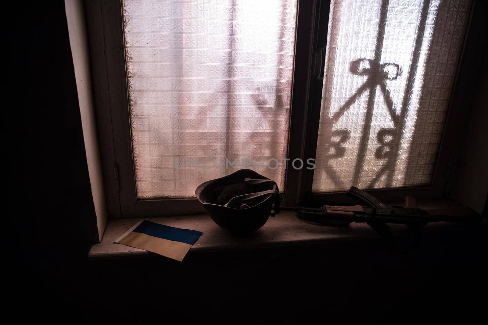 Conceptual photo of war between Russia and Ukraine. Ukraine and Russia flags on windowsill at night. Old creepy room with window. by Zeferli