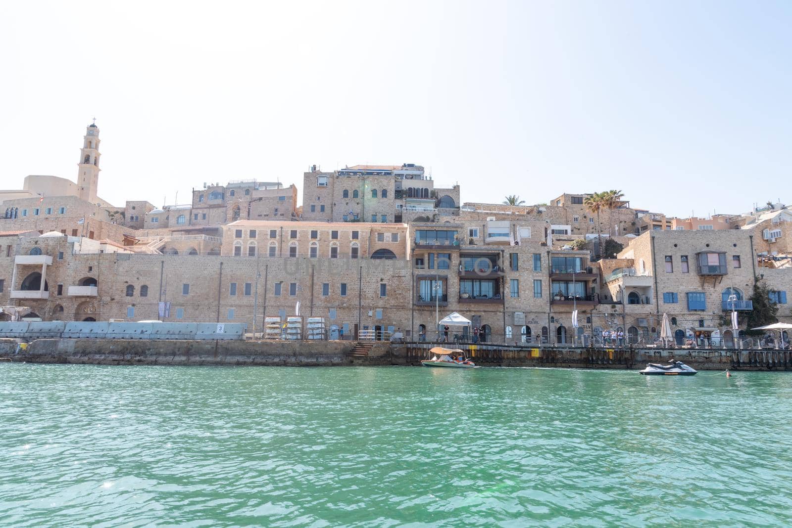 JAFFA OLD CITY, ISRAEL - MAY 10, 2022: View of Old Jaffa Port with beautiful buildings and houses in a sunny day. Panoramic view. High quality photo