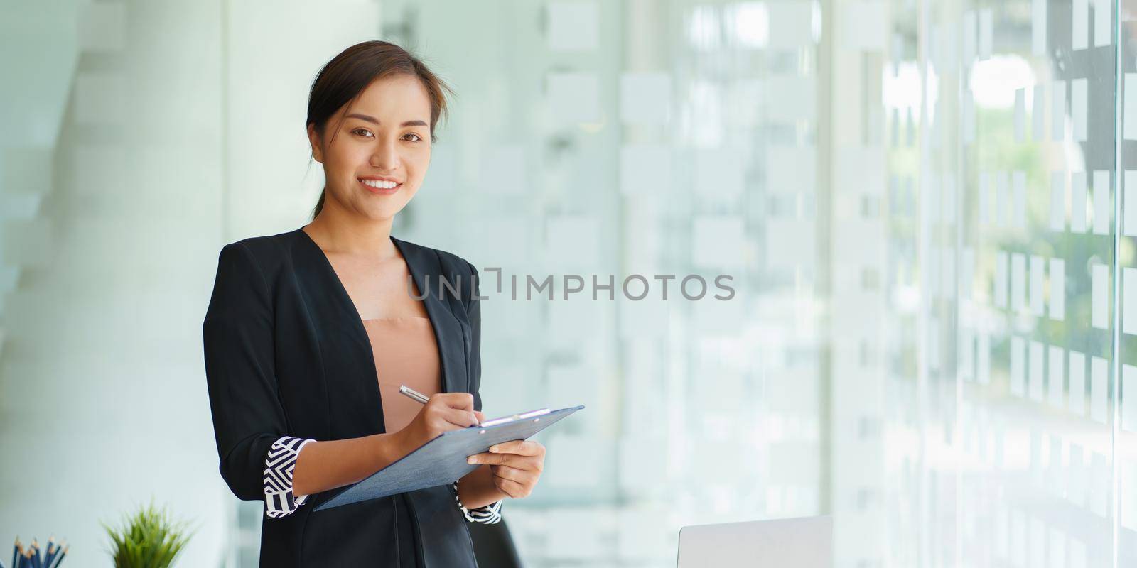 A portrait of Asian happy Businesswoman smiling and working at office