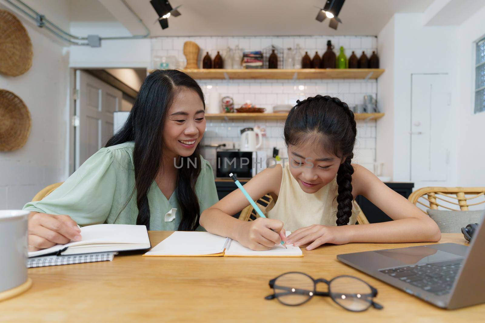 Homeschool Asian mother and little young girl student learning online class. E-learning Online Education concept