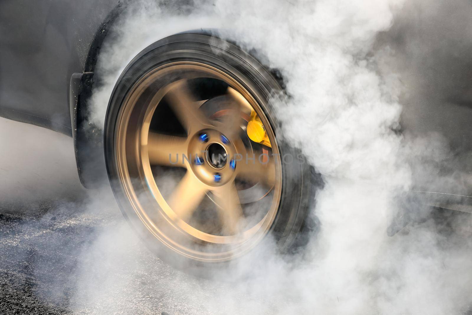 Drag racing car burns rubber off its tires in preparation for the race