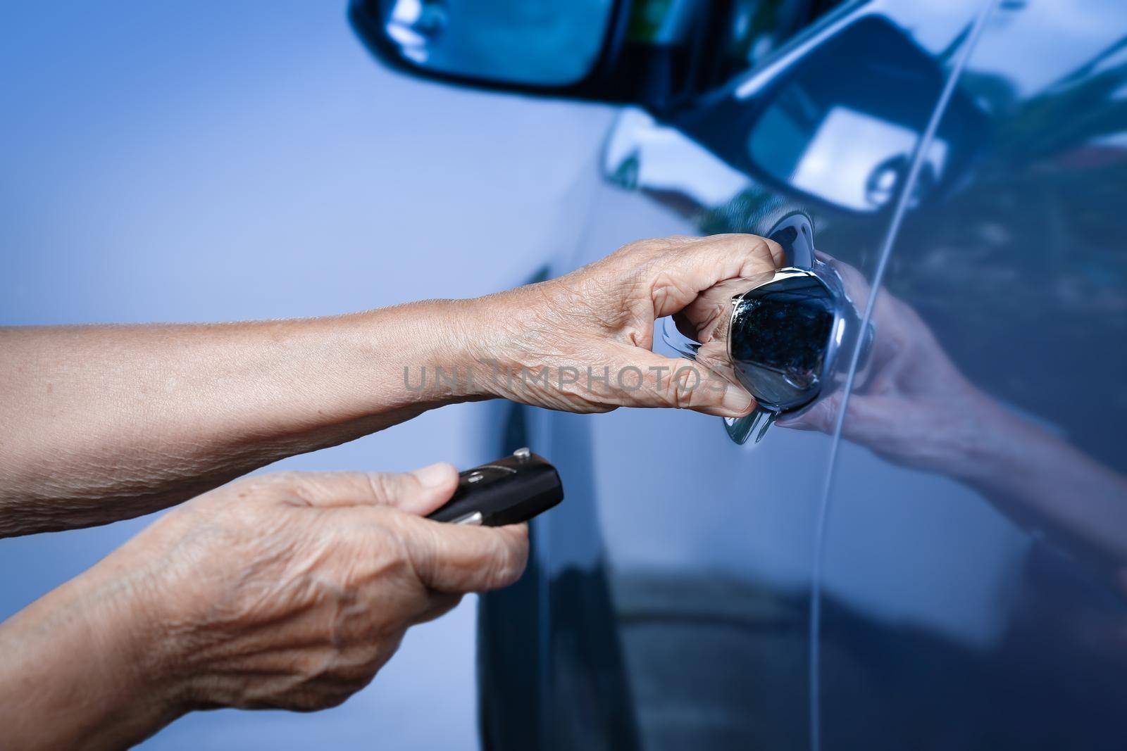 Elderly woman hand open the car on key car alarm systems by toa55