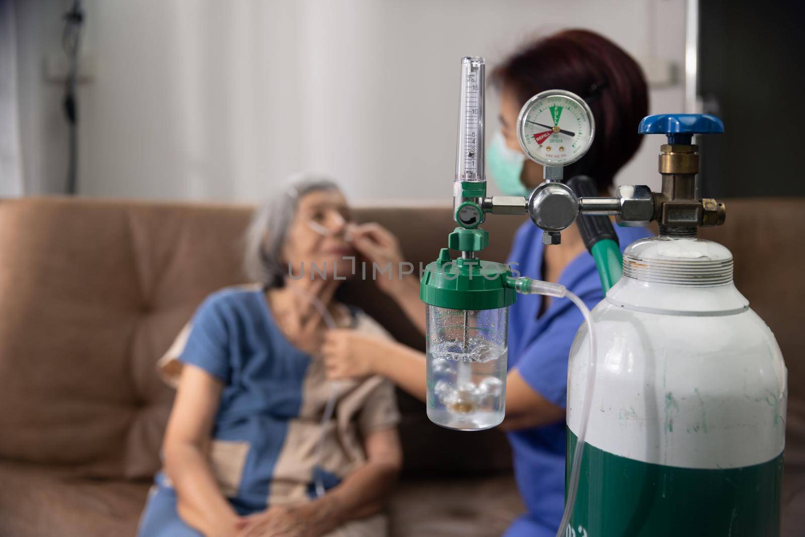 Elderly woman wearing oxygen nasal canula at home. by toa55