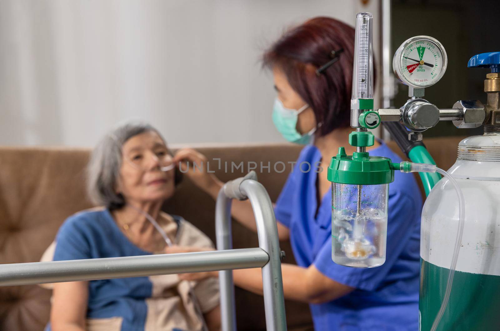 Elderly woman wearing oxygen nasal cannula at home. by toa55