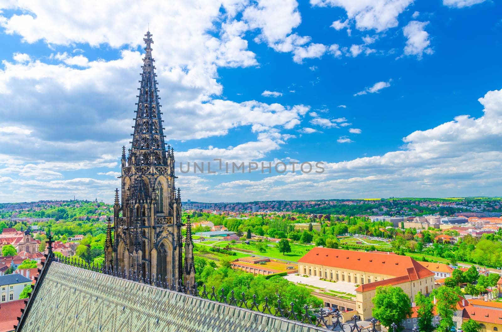 Top aerial view of Prague Royal Garden and roof and spire of St. Vitus cathedral, blue sky white clouds background, Bohemia, Czech Republic