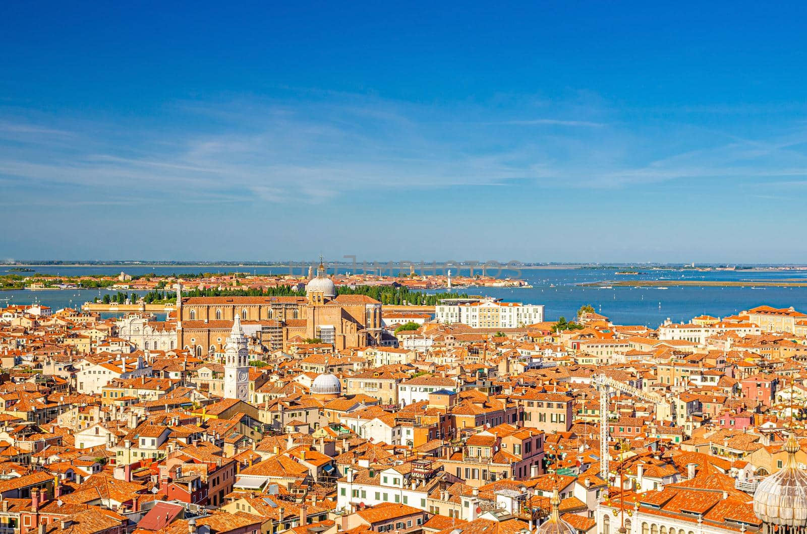 Aerial panoramic view of Venice city historical centre with old buildings red tiled roofs, Basilica dei Santi Giovanni e Paolo and islands of Venetian Lagoon, Veneto Region, Italy. Venice cityscape.