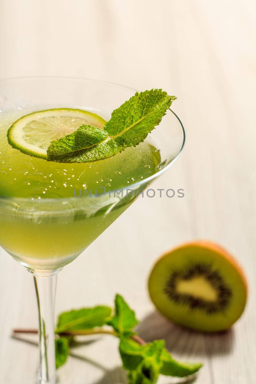 Kiwi jelly with lime pieces in the glass topped mint leaves Close up selective focus with shallow depth of field