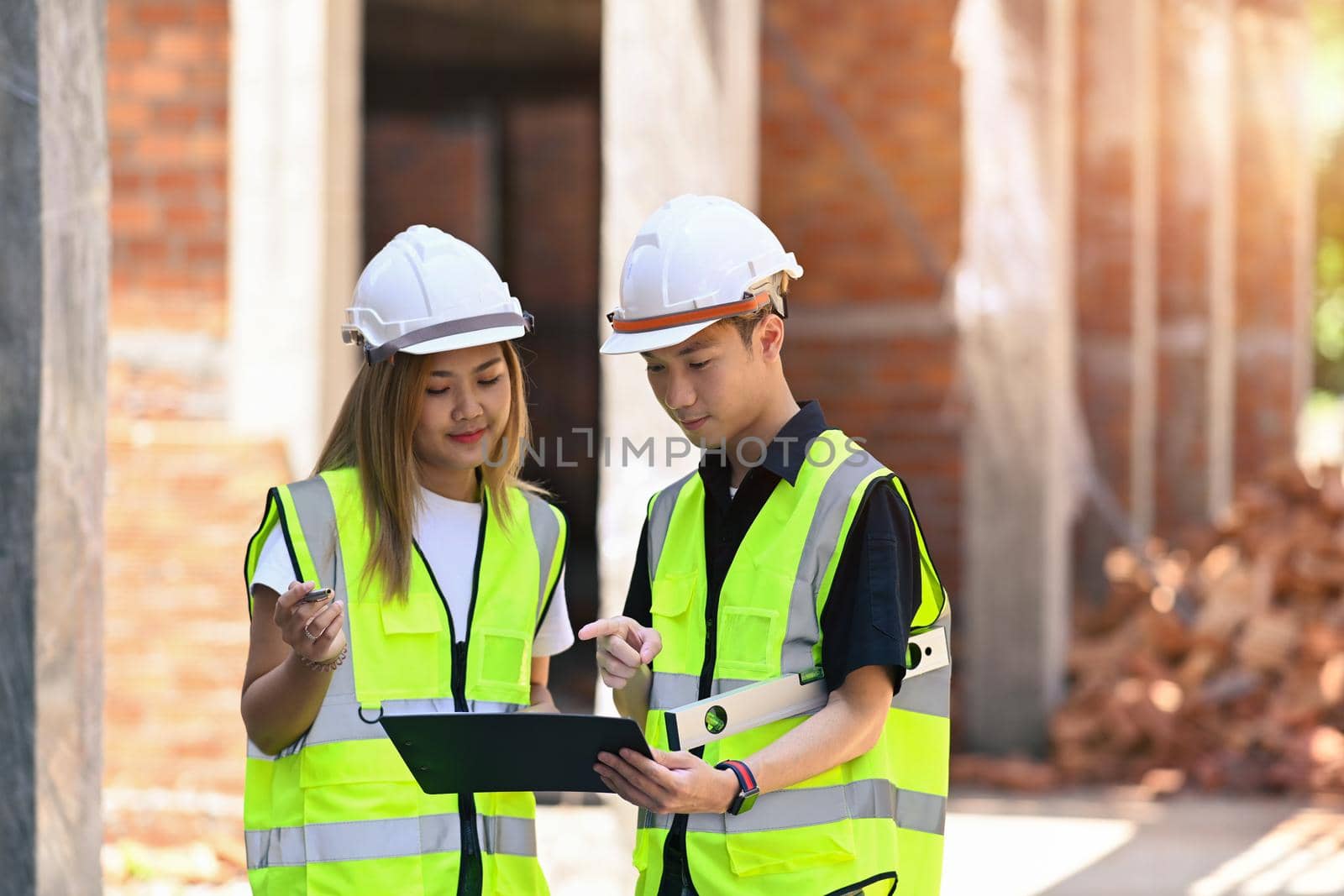 Team of construction engineers discussing the design of construction together by prathanchorruangsak