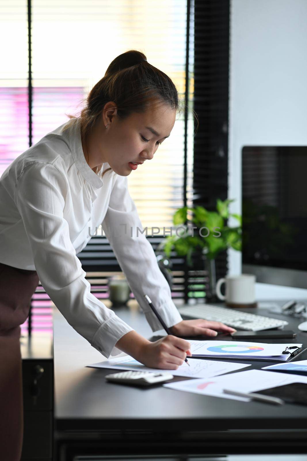 Female accountant or banker calculating tax and salary at office desk. Savings, finances and economy concept.