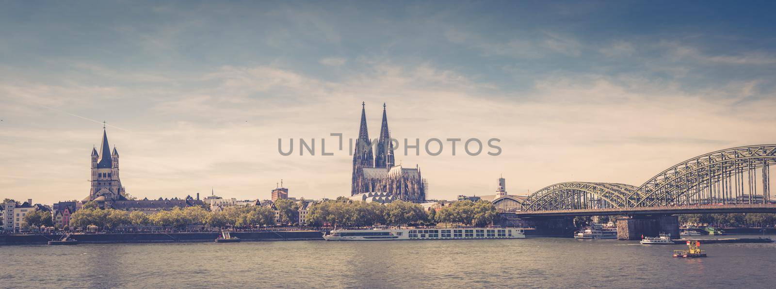 Panorama of Cologne city historical centre with Cologne Cathedral of Saint Peter, Great Saint Martin Roman Catholic Church buildings and Hohenzollern Bridge across Rhine river. Cologne panoramic view