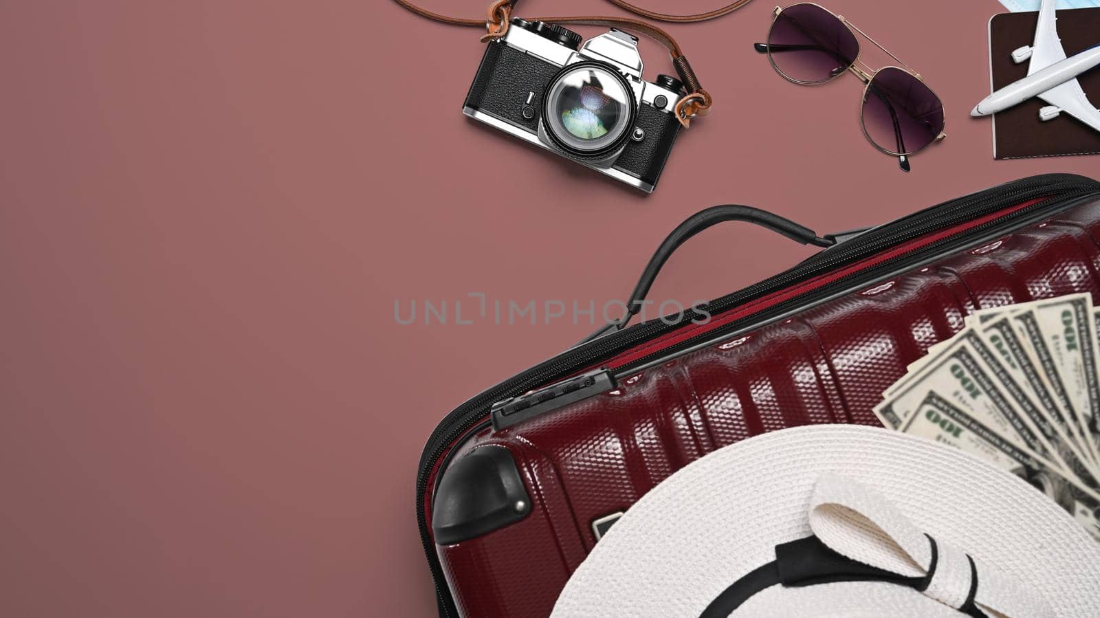 Flat lay suitcase with traveler accessories on pink background. Holidays, travel, tourism, flight luggage concept.