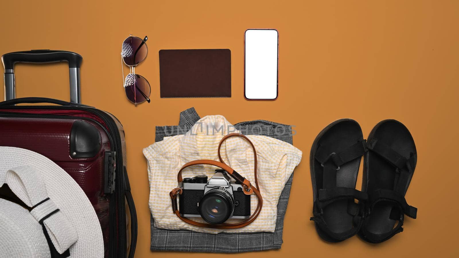 Suitcase with traveler accessories on white orange background. Packing for a new journey.