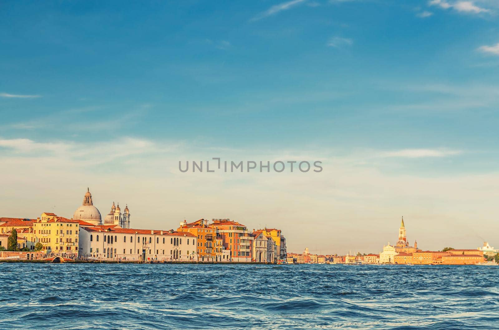 Venice cityscape with water of Giudecca canal of Venetian lagoon, embankment of Fondamenta Zattere Ai Gesuati and San Giorgio Maggiore island with catholic church and campanile bell tower, Italy