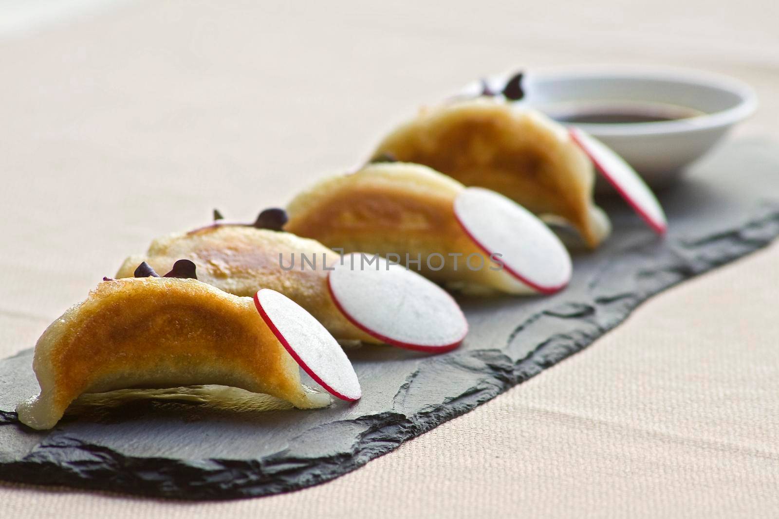 Four Gyoza dim sum dumplings with radishes