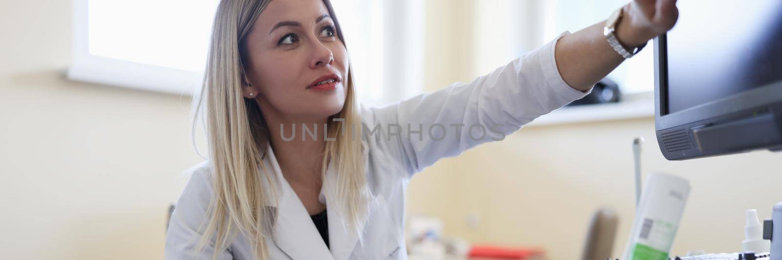 A woman doctor makes an ultrasound of the abdomen to a female patient, close-up. Diagnostics of pregnancy and determination of the sex of the child