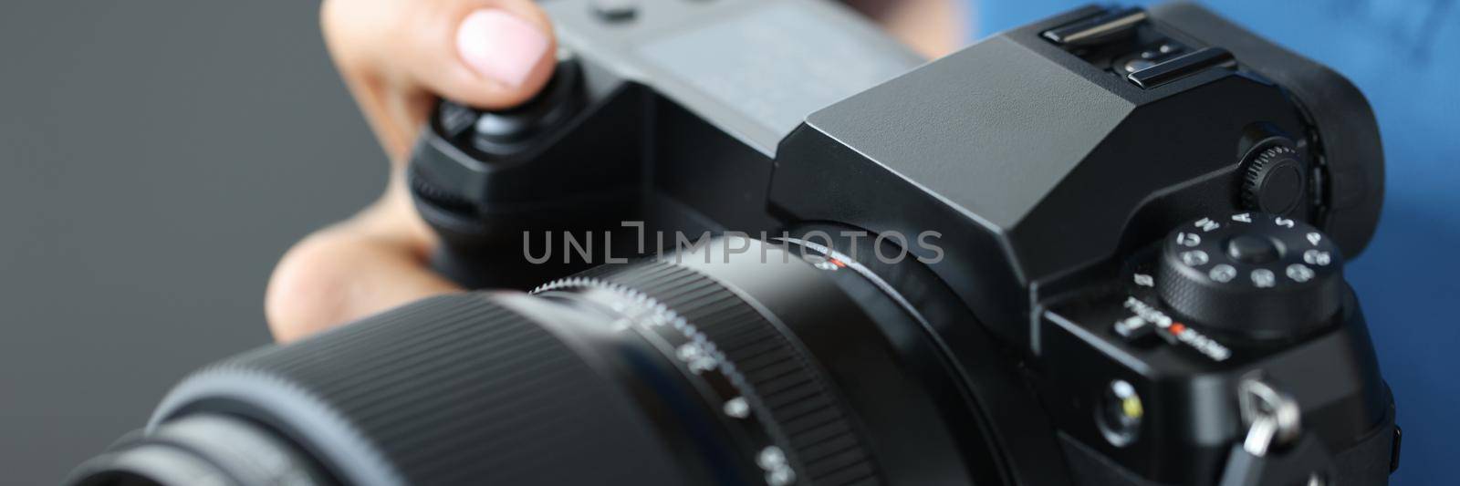 Woman holding modern camera for photos, close-up by kuprevich