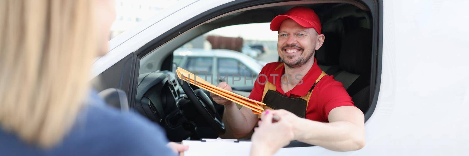 The courier sits in the car and hands the package to the woman, close-up. Delivery of documents in the city, orders from online stores