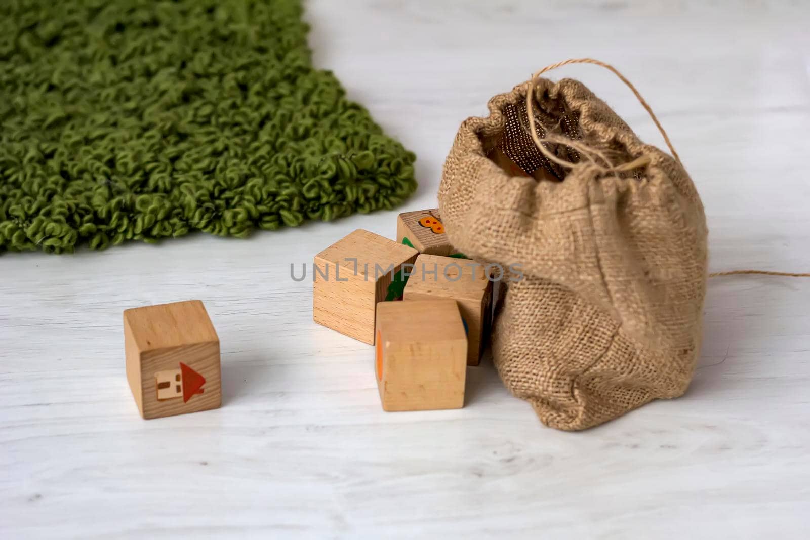 wood cube building blocks and bag on the floor in a home