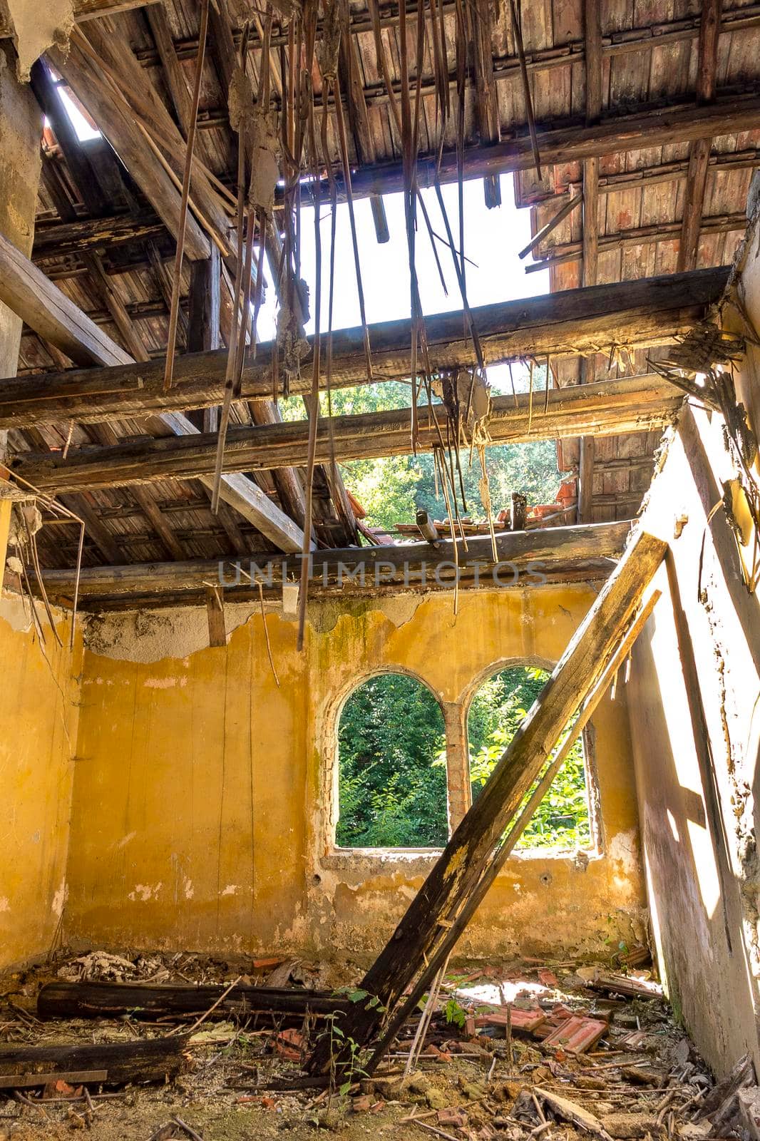 the abandoned interior of an old house with a broken roof