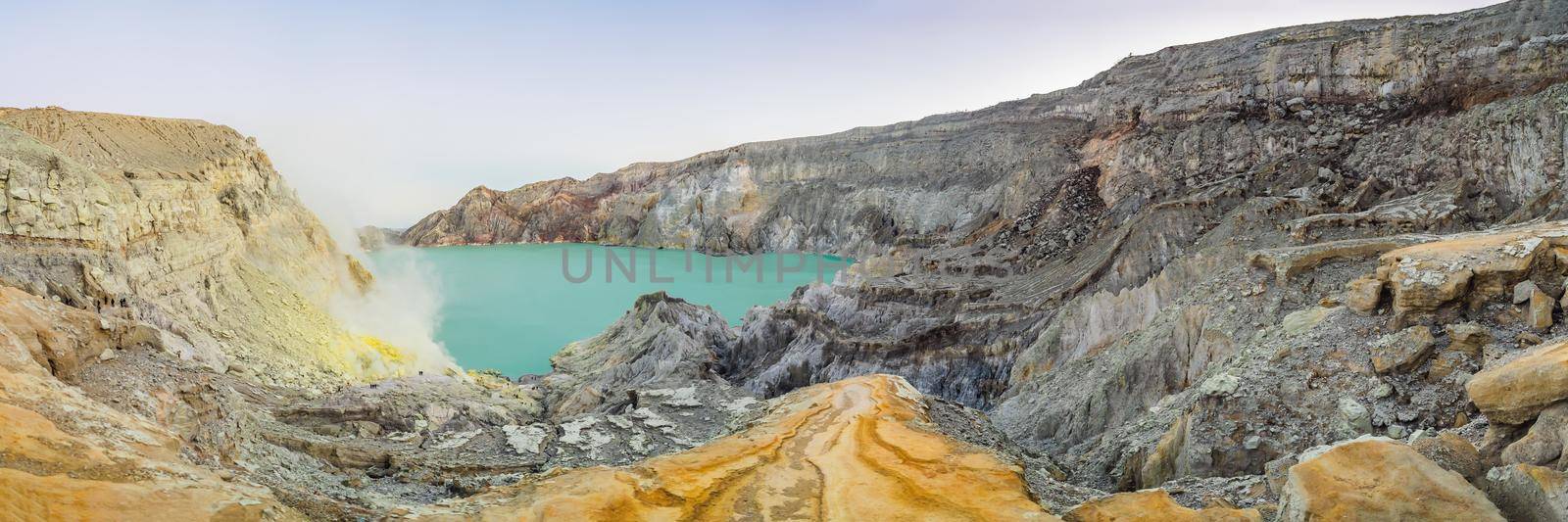 Panoramic shot of the Ijen volcano or Kawah Ijen on the Indonesian language. Famous volcano containing the biggest in the world acid lake and sulfur mining spot at the place where volcanic gasses come from the volcano.