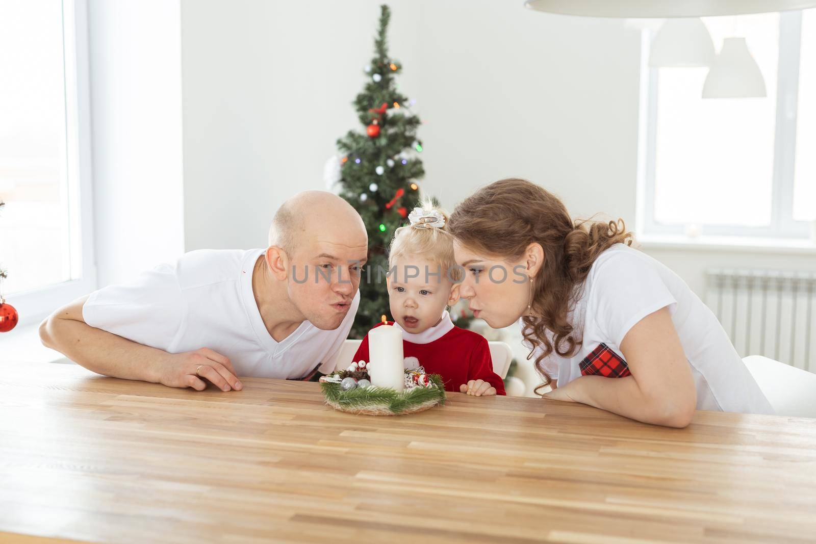 Baby child with hearing aid and cochlear implant having fun with parents in christmas room. Deaf , diversity and health concept by Satura86