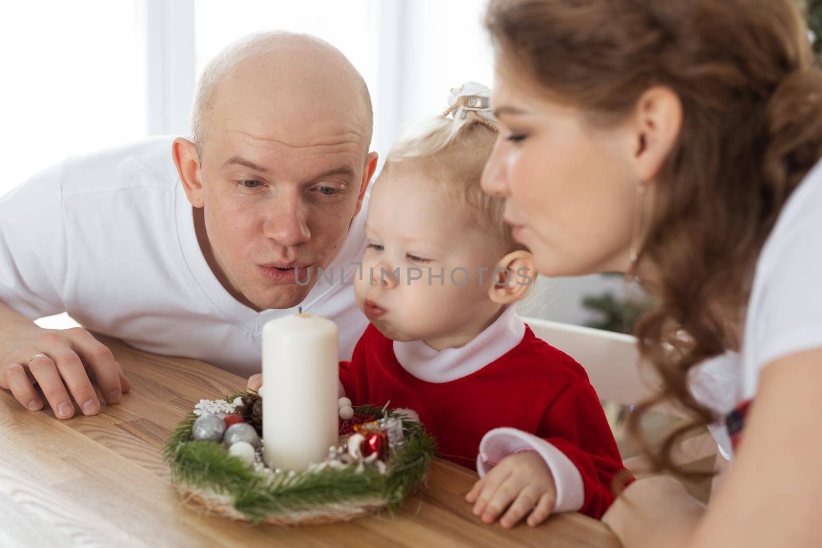 Baby child with hearing aid and cochlear implant having fun with parents in christmas room. Deaf , diversity and health concept by Satura86