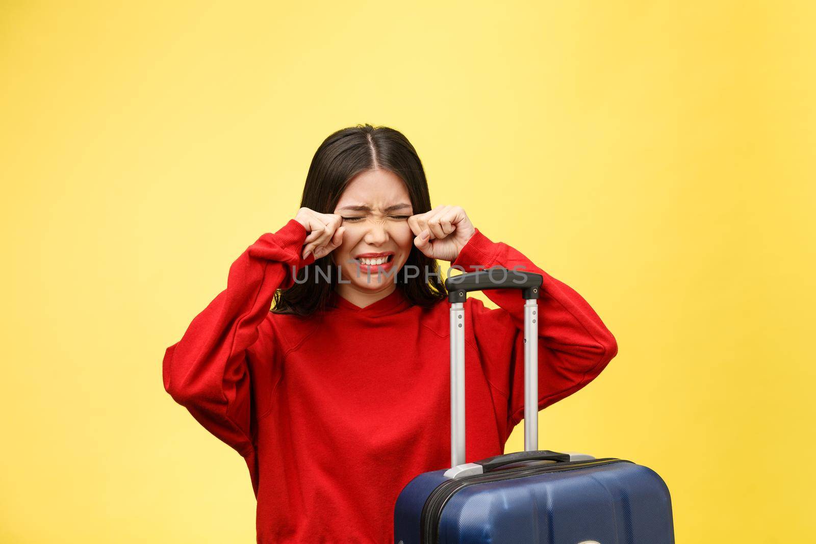 Upset tourist woman in summer casual clothes sit on suitcase put hands on head isolated on yellow orange background. Female traveling abroad to travel on weekends getaway. Air flight journey concept. by Benzoix
