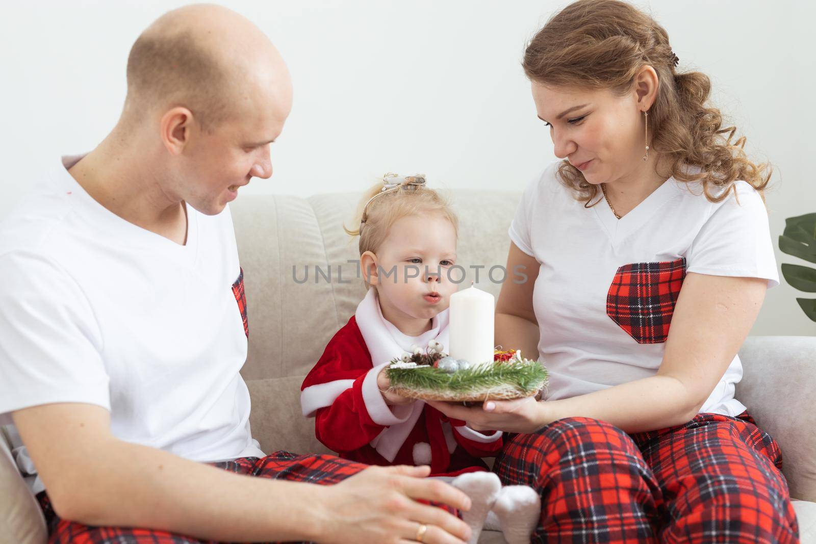 Baby child with hearing aid and cochlear implant having fun with parents in christmas room. Deaf and health