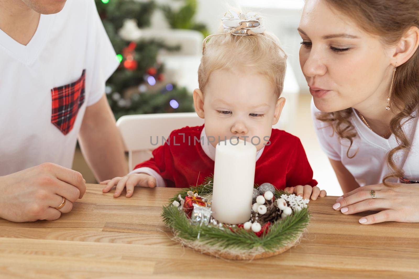 Baby child with hearing aid and cochlear implant having fun with parents in christmas room. Deaf , diversity and health concept by Satura86