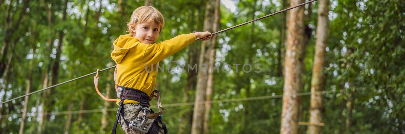 Little boy in a rope park. Active physical recreation of the child in the fresh air in the park. Training for children. BANNER, LONG FORMAT