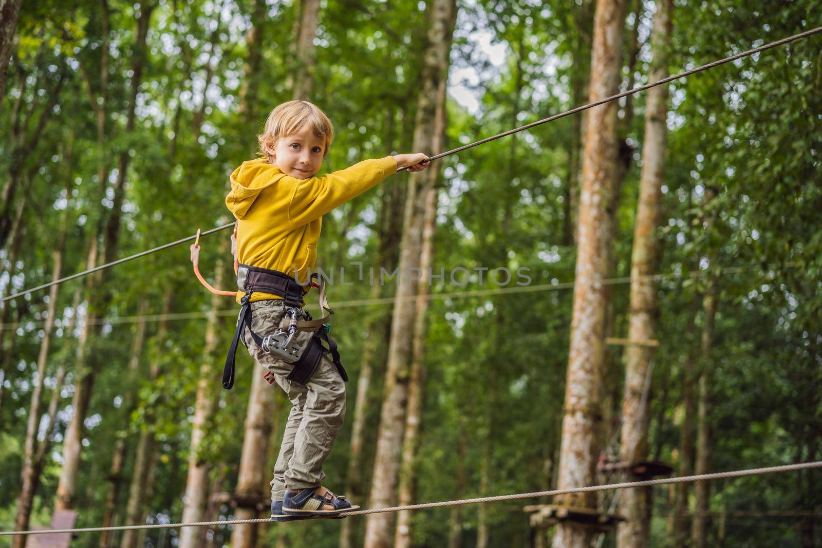 Little boy in a rope park. Active physical recreation of the child in the fresh air in the park. Training for children.
