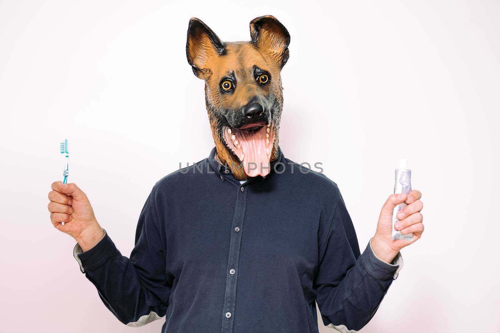 person with dog mask holding brush and toothpaste by raulmelldo