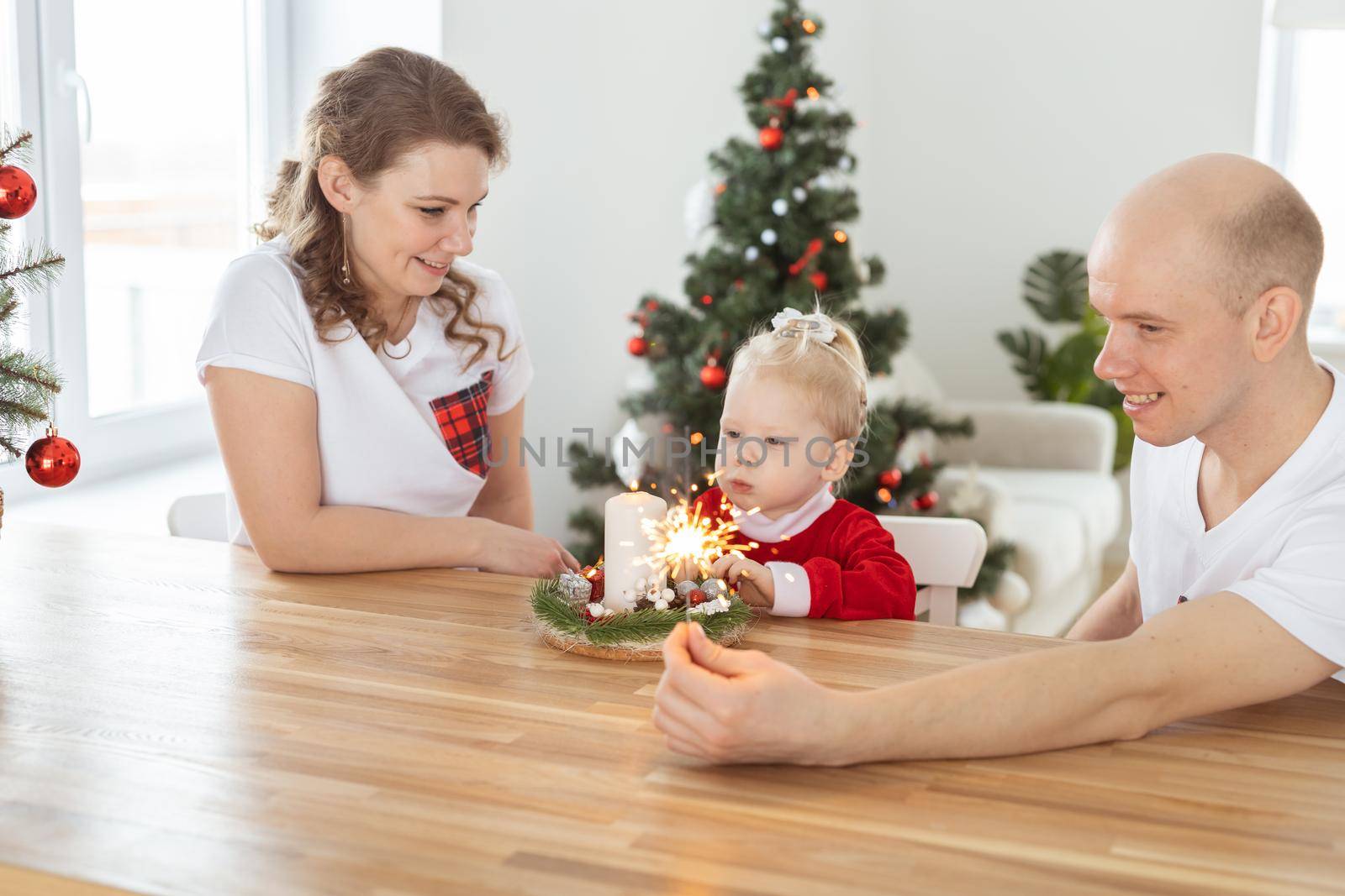 Baby child with hearing aid and cochlear implant having fun with parents in christmas room. Deaf , diversity and health and diversity by Satura86