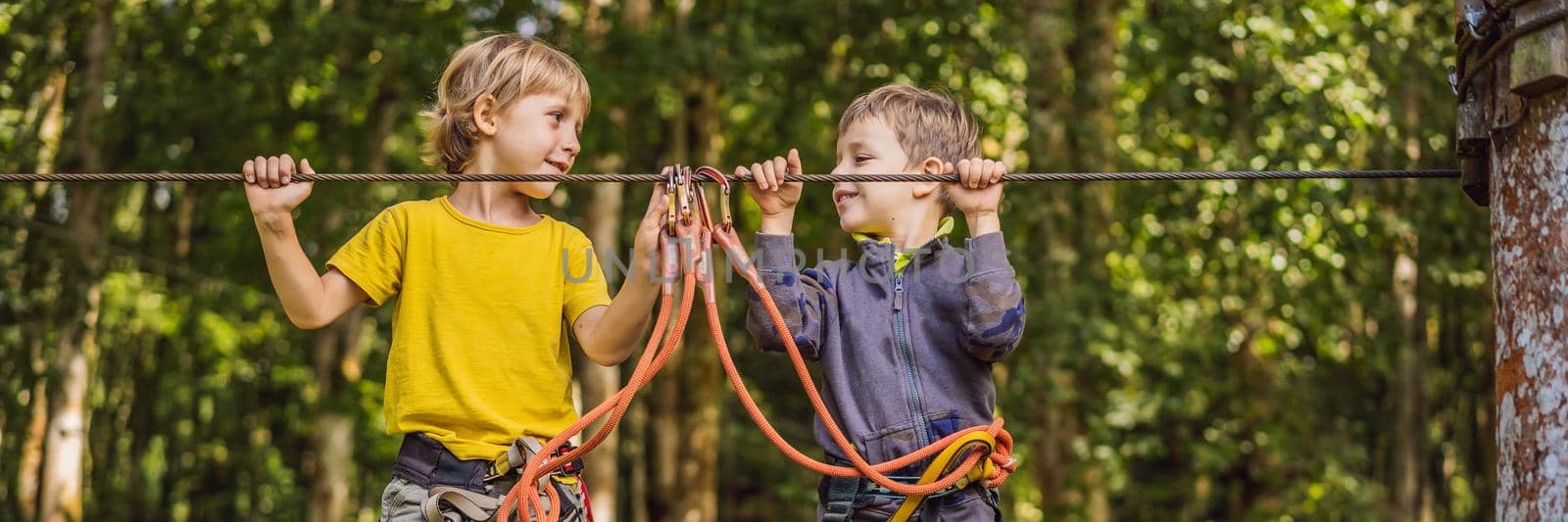 Two little boys in a rope park. Active physical recreation of the child in the fresh air in the park. Training for children BANNER, LONG FORMAT by galitskaya