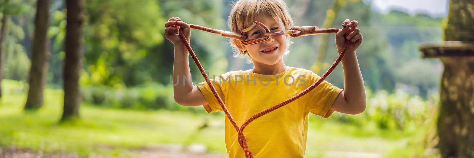 Little boy in a rope park. Active physical recreation of the child in the fresh air in the park. Training for children BANNER, LONG FORMAT by galitskaya