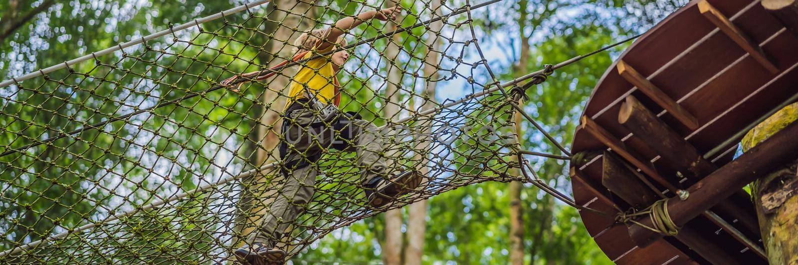 Little boy in a rope park. Active physical recreation of the child in the fresh air in the park. Training for children BANNER, LONG FORMAT by galitskaya